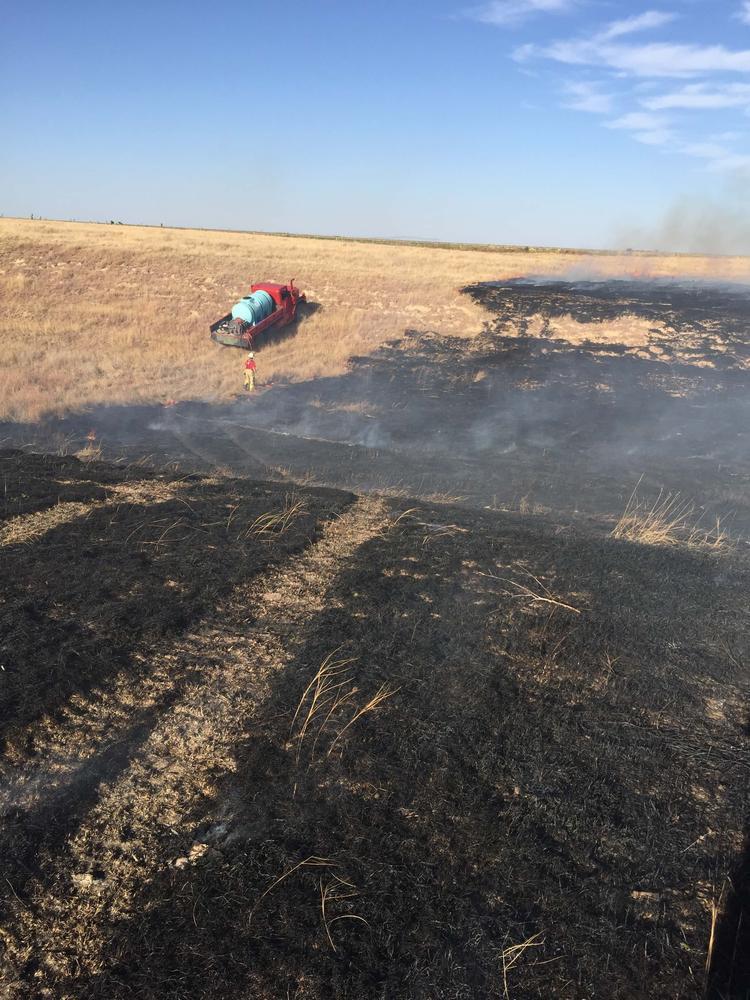 Water truck working to contain grass fire