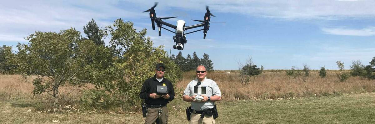 two officers with flying drone camera
